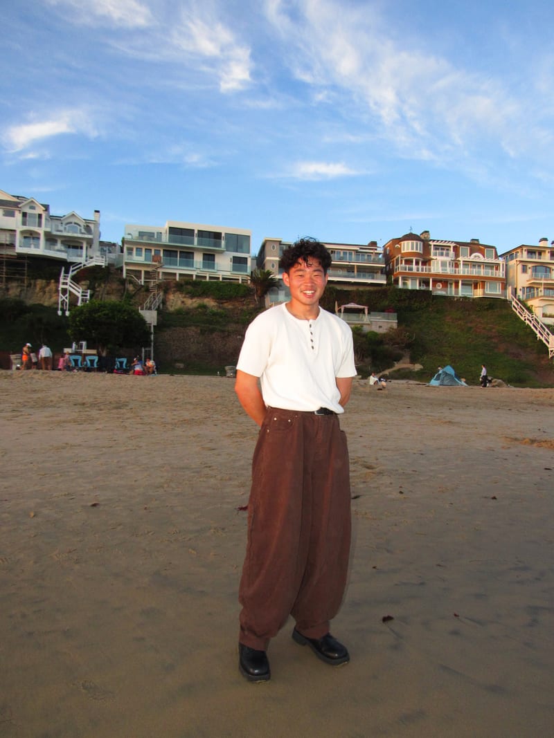 Isaac Lee standing on the sand below Inspiration Point, Newport Beach