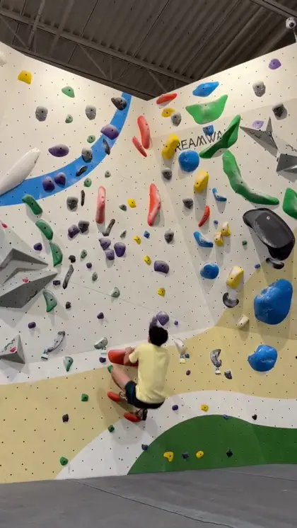 Isaac climbing Sneaky, a V5 boulder problem, in Aliso Viejo