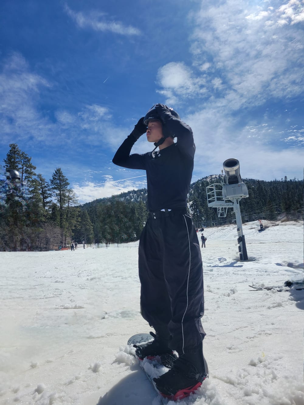 Isaac Lee strapping on a helmet at the top of a run